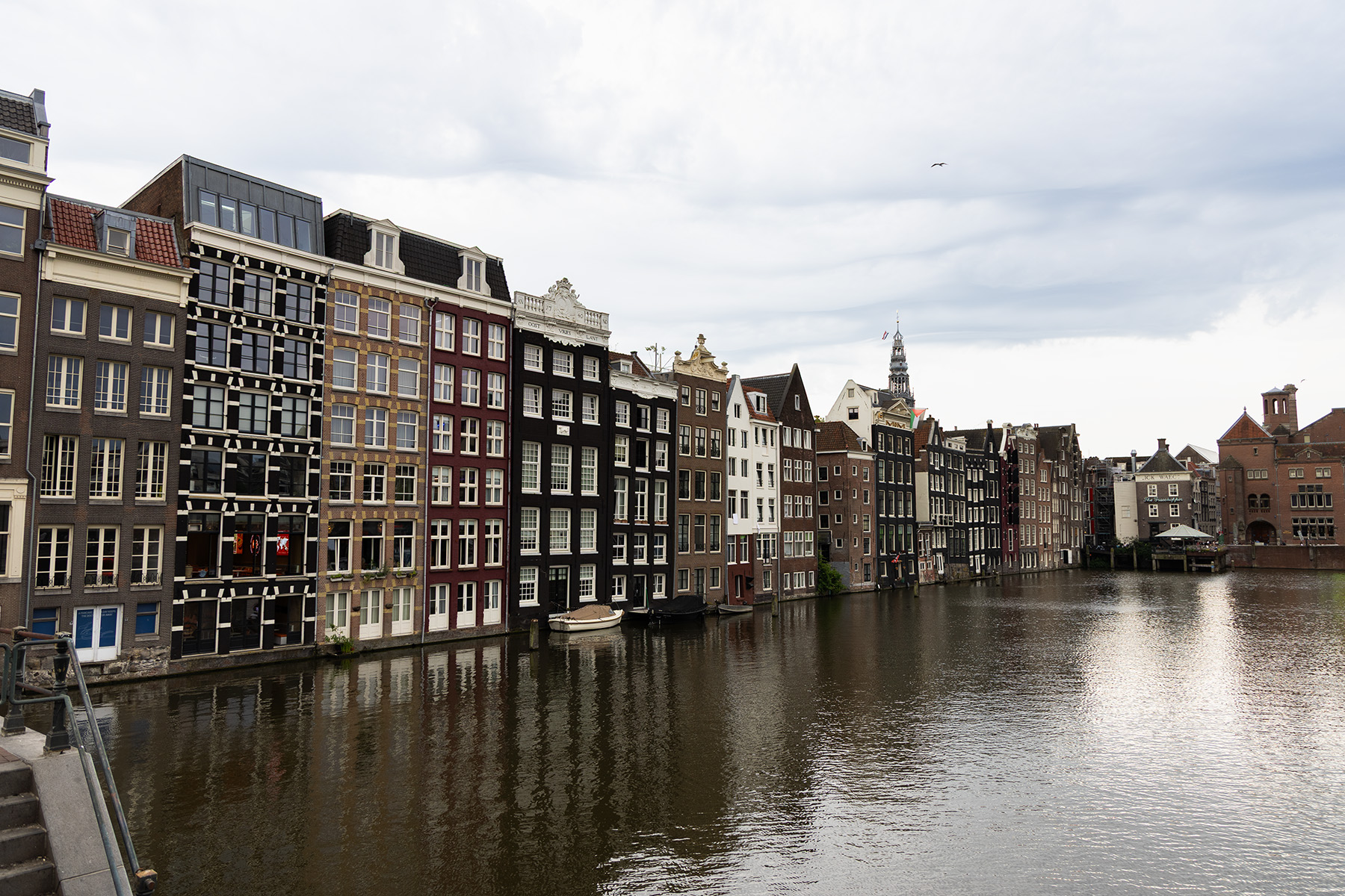 Amsterdam canal with historic houses on a cloudy day.